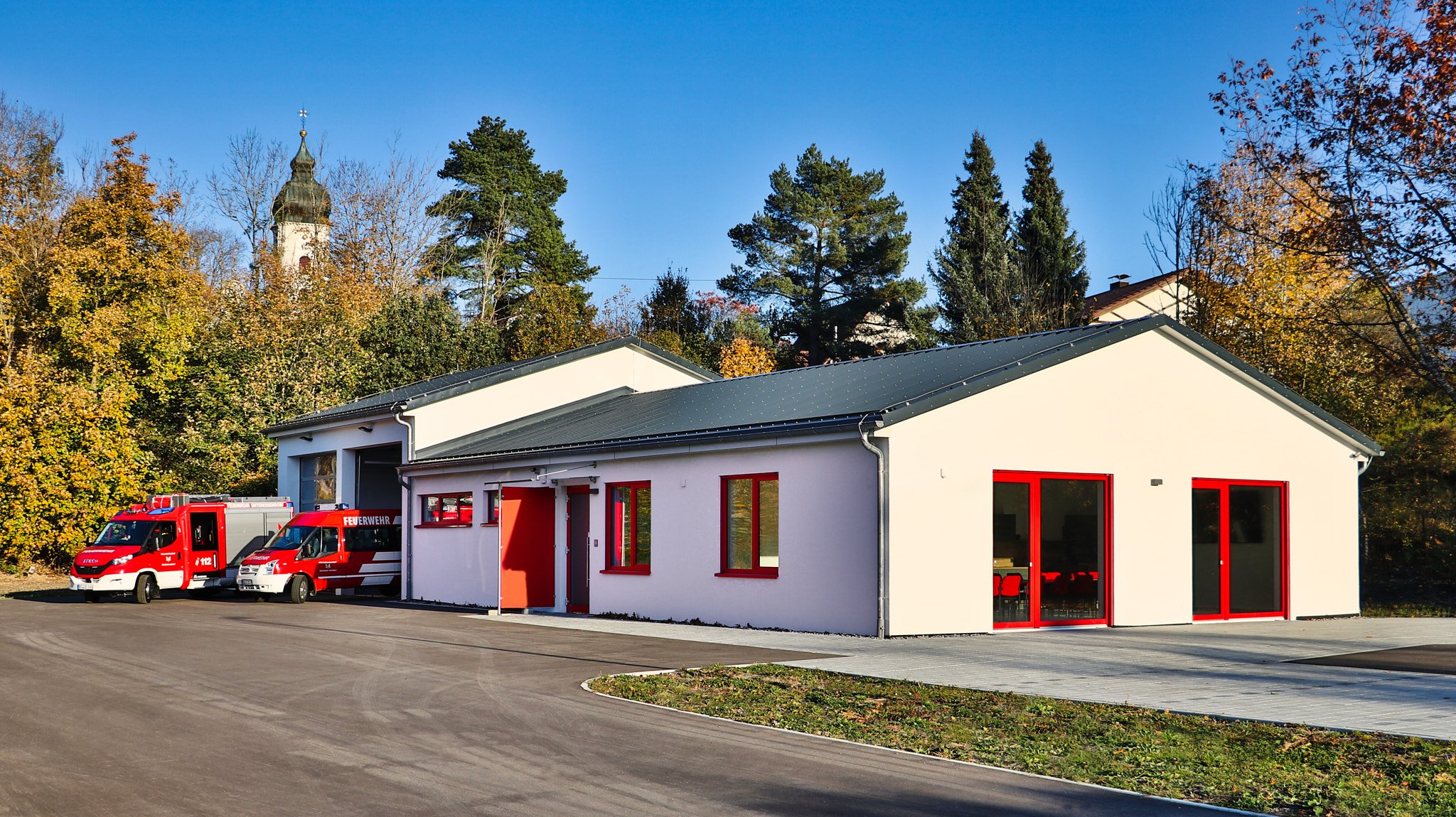 Feuerwehrhaus Unteressendorf mit zwei roten Feuerwehrfahrzeugen